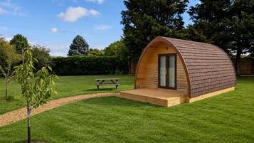 A small, single-story wooden structure with a curved roof, a door, and a small porch area.