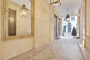 A corridor with a large ornate mirror, hanging lanterns, and a Christmas tree. - Charming studio 2P - Musée d'Orsay / Louvre (Paris)
