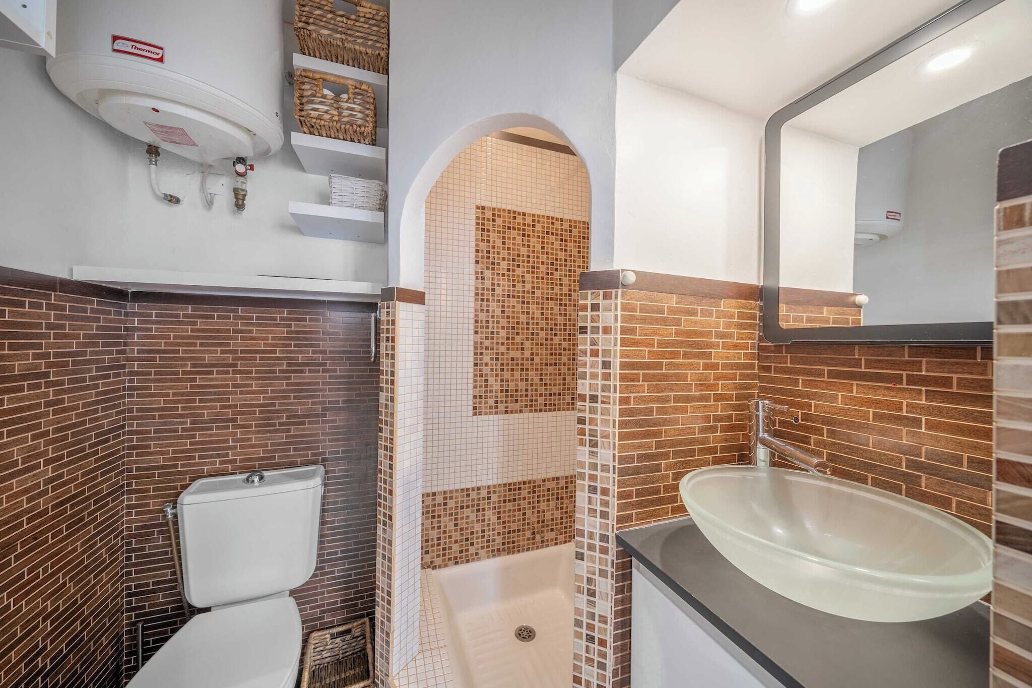 A bathroom with a toilet, a shower, and a sink.