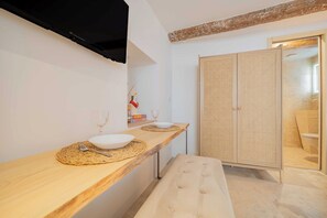 Ein Badezimmer mit einem Holzlagerplatz, einem weißen Waschbecken, einem Handtuch und einer Rattantür.