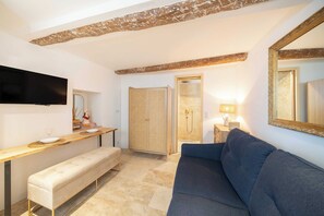 Ein modernes Wohnzimmer mit Flachbildfernseher, einer Bank, einem Sofa, einem Holzschrank und einem Spiegel.
