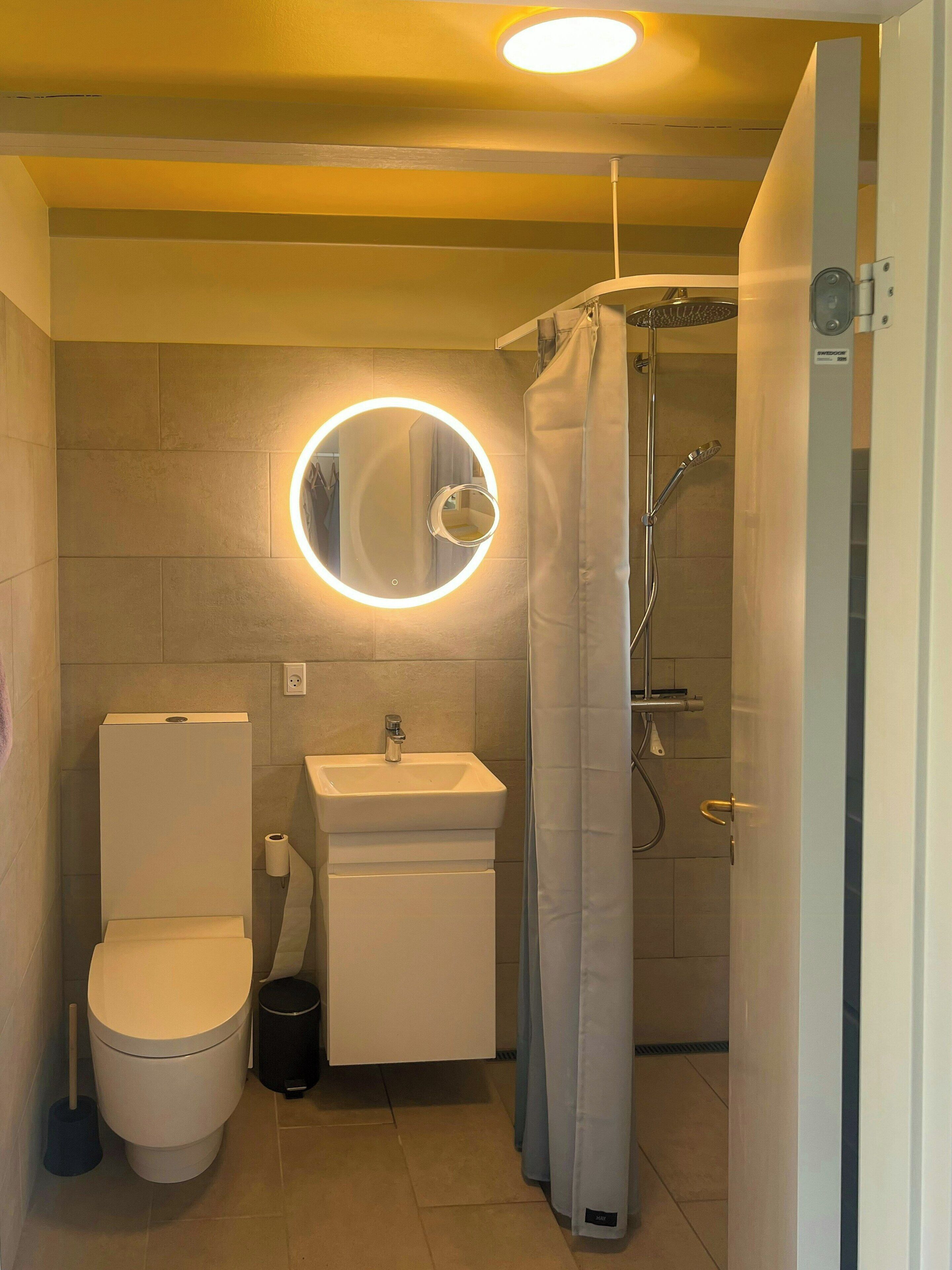 Un bany compacte amb vàter, rentapèus i plat de dutxa.