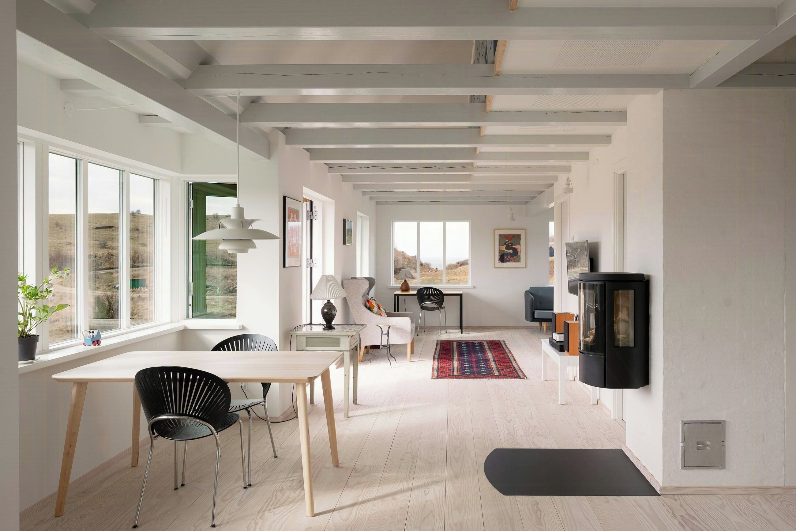 Ein modernes Interieur mit Essbereich, einer Couch, einem Fernseher und einem Kamin.