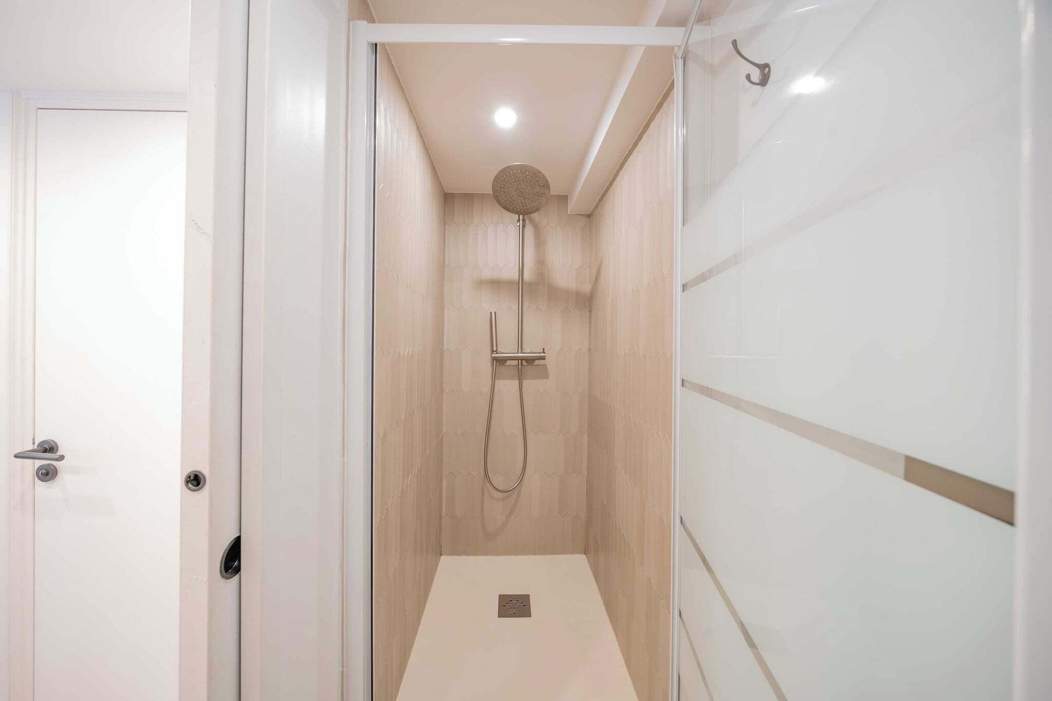 A modern bathroom with a shower, a toilet, and a sink.