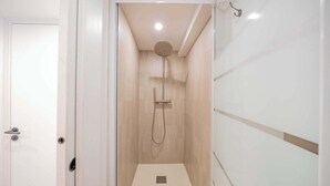 Un baño moderno con ducha, inodoro y lavabo.
