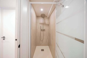 Une salle de bain moderne équipée d’une douche, de toilettes et d’un lavabo.