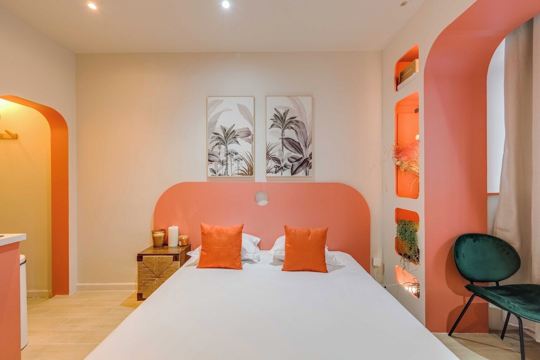 Une chambre avec un grand lit, deux oreillers, une table de chevet avec une bougie et une chaise.