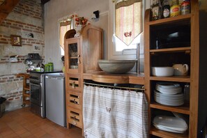 A kitchen with a wooden cabinet, a sink, and a stove. - Pretty little Picardy house by the water (Epagne-Epagnette)