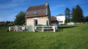 A small brick house with a sloped roof, a white fence, and a grassy field. - Pretty little Picardy house by the water (Epagne-Epagnette)