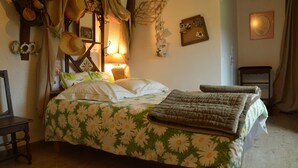 A bed with a floral bedspread, a bedside lamp, and a small bedside table. - Pretty little Picardy house by the water (Epagne-Epagnette)