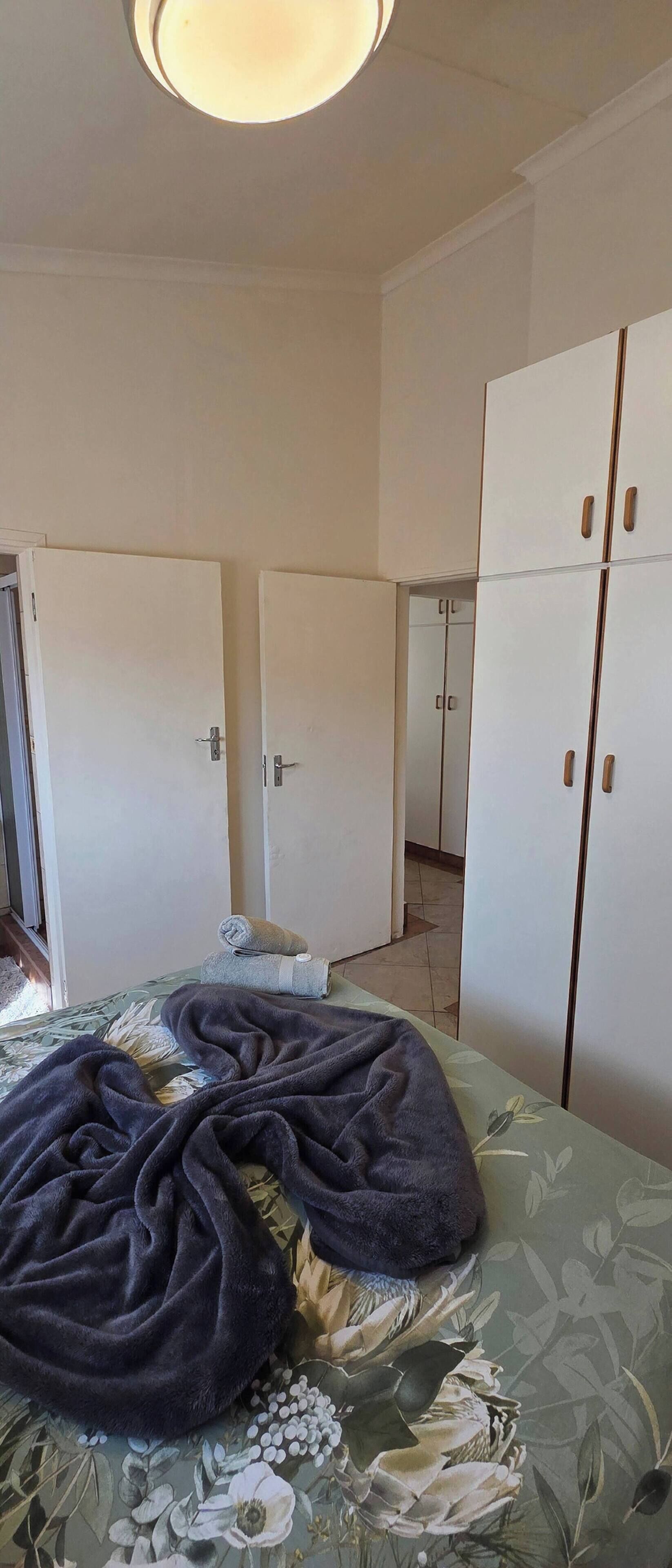 A bedroom with a bed, a wardrobe, and a door.