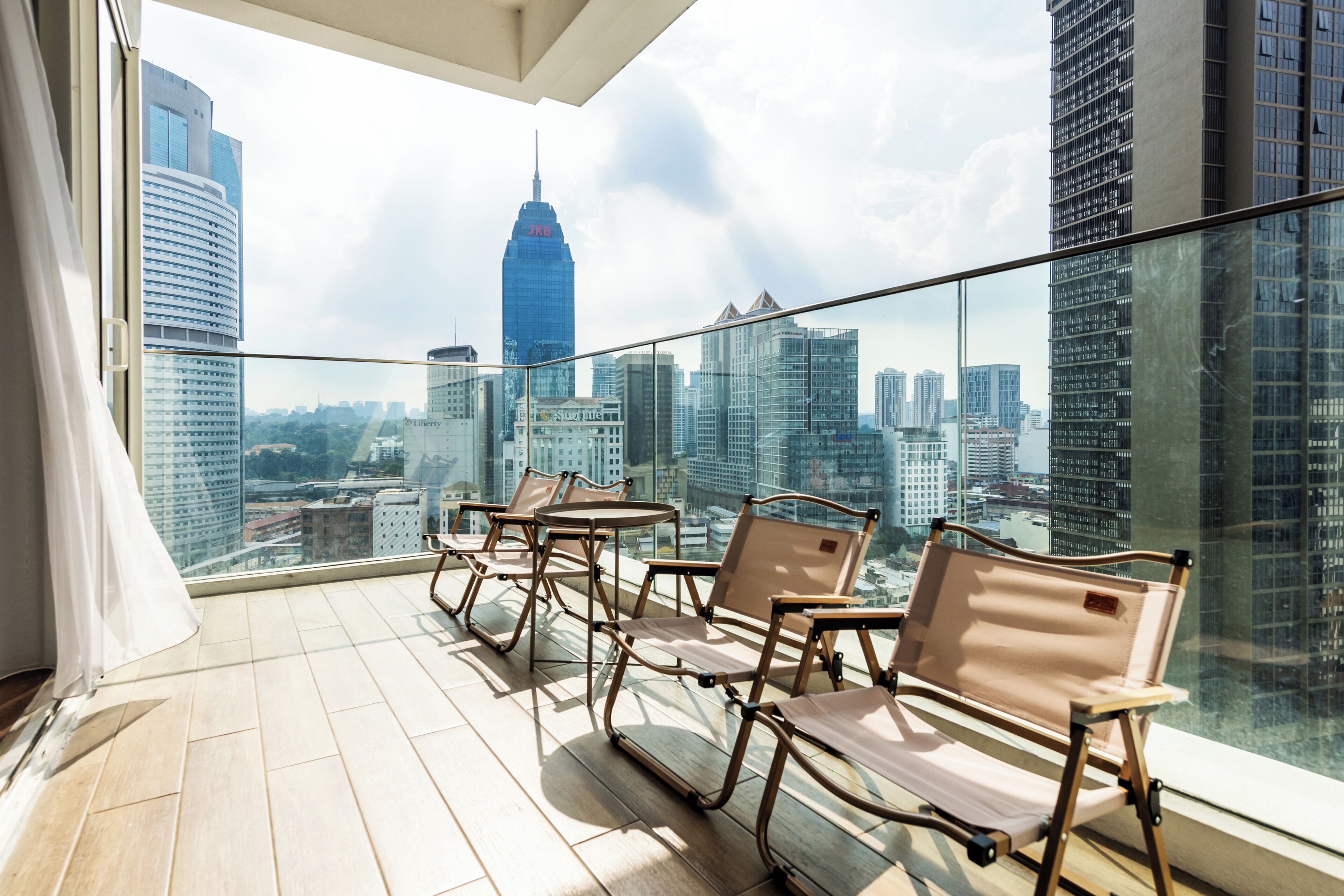 A balcony with a city view, including a prominent skyscraper.