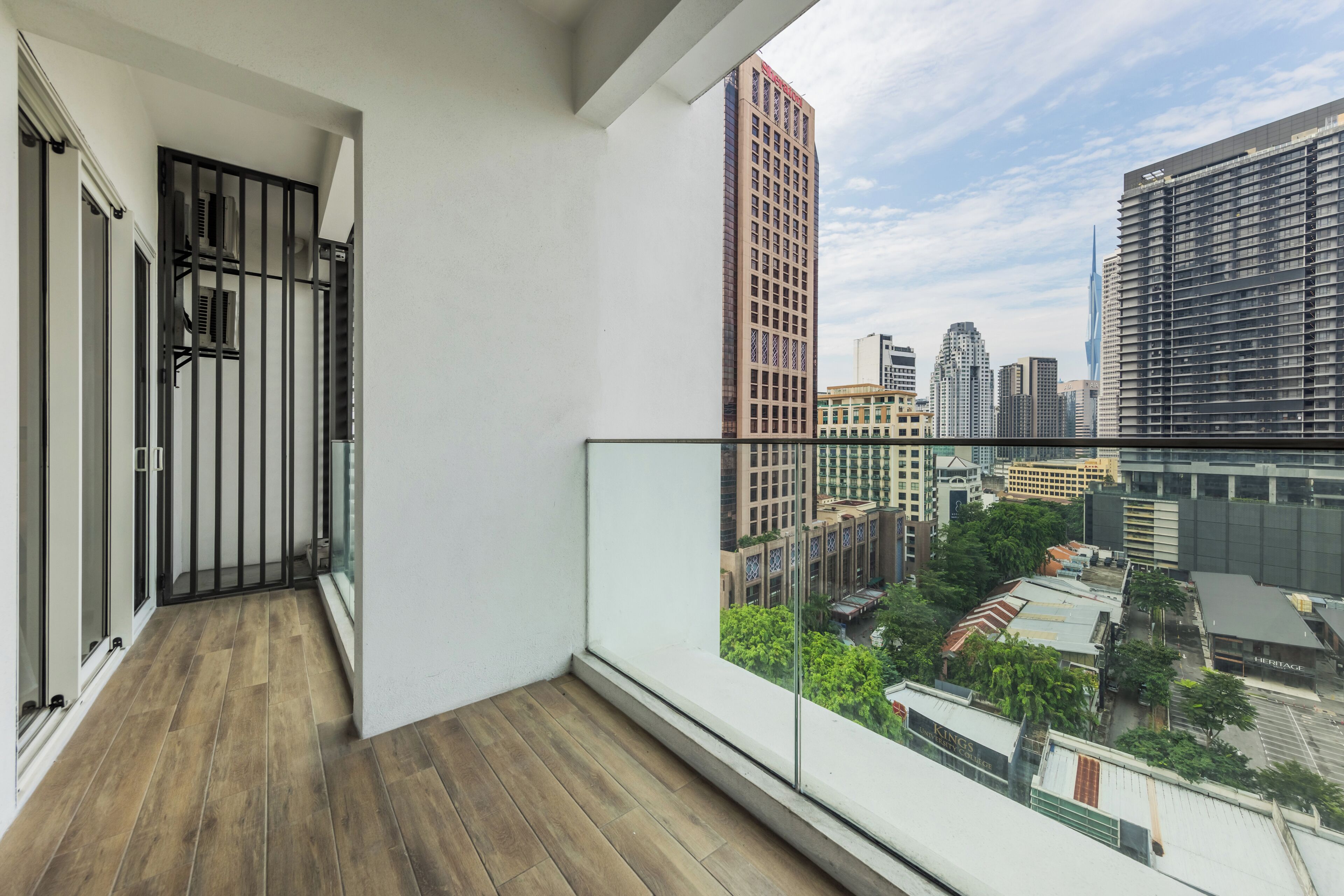 A balcony with a view of a cityscape, including high-rise buildings and a university.