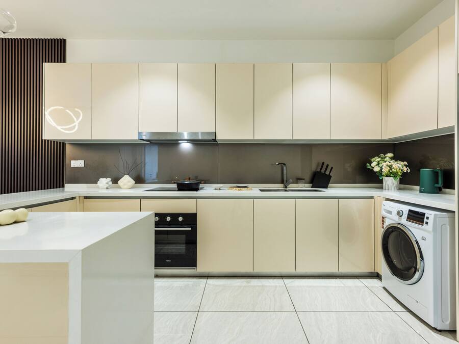 Una cocina moderna con horno empotrado, lavadora y lavaplatos.