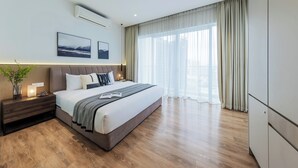 A modern hotel room with a large bed, a bedside table with a lamp, and a view of the city through large windows. - Veone Hotel  Kuala Lumpur (Kuala Lumpur)