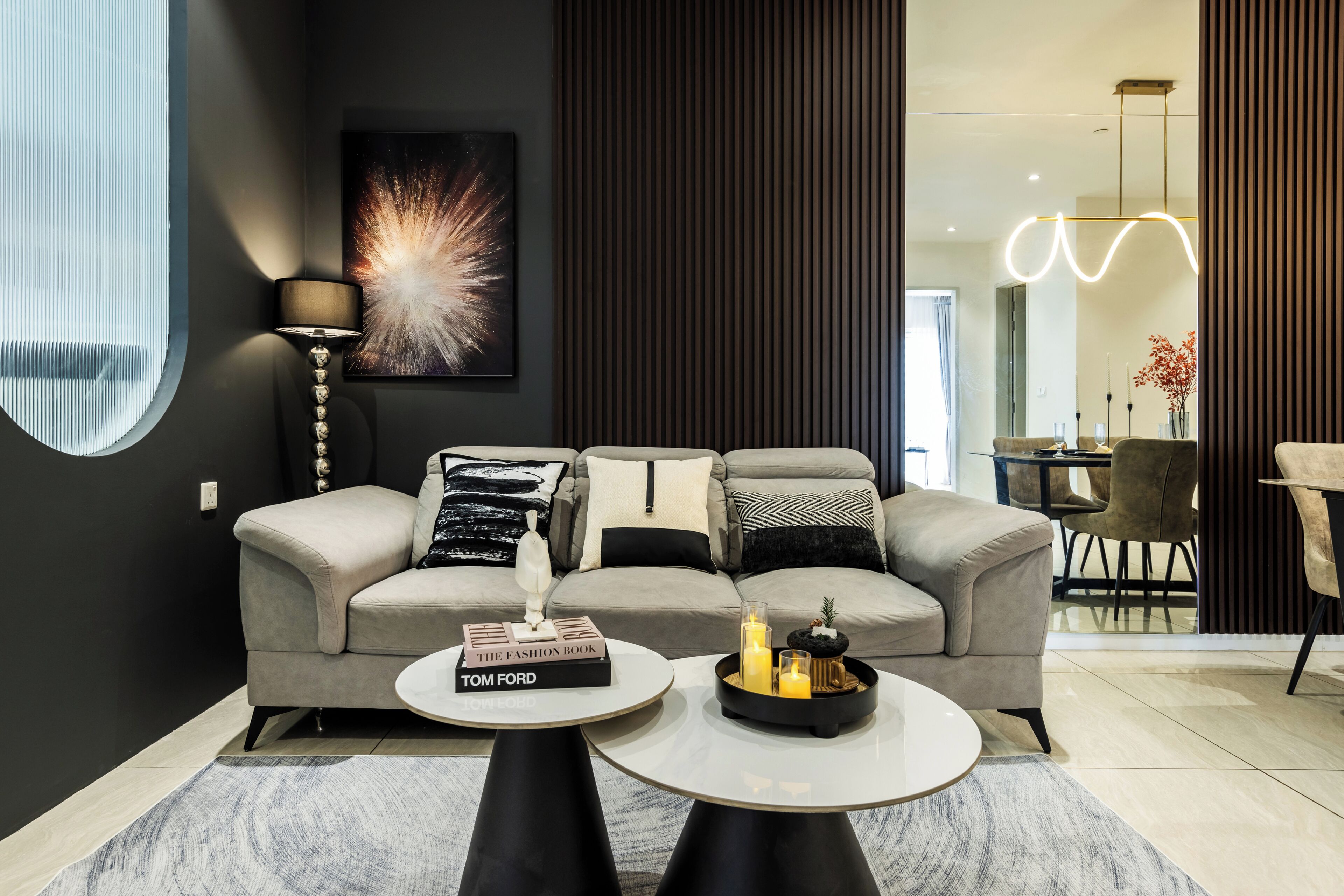 A modern living room with a sofa, a round coffee table, and a floor lamp.