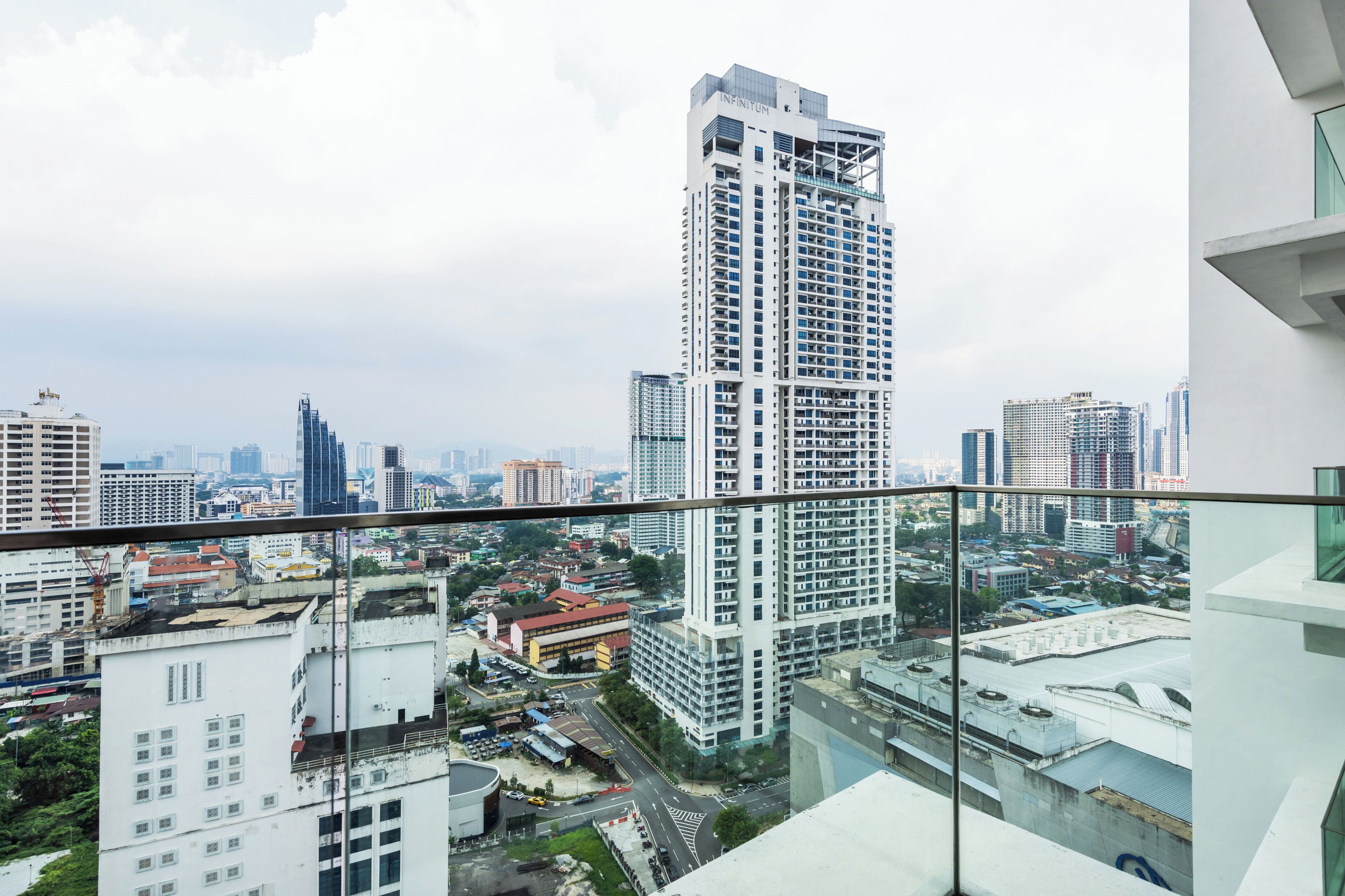A high-rise building with a modern architectural design, featuring a prominent glass facade and multiple balconies.