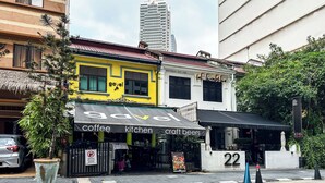 A building with a yellow facade, a coffee shop, and a restaurant. - Veone Hotel  Kuala Lumpur (Kuala Lumpur)