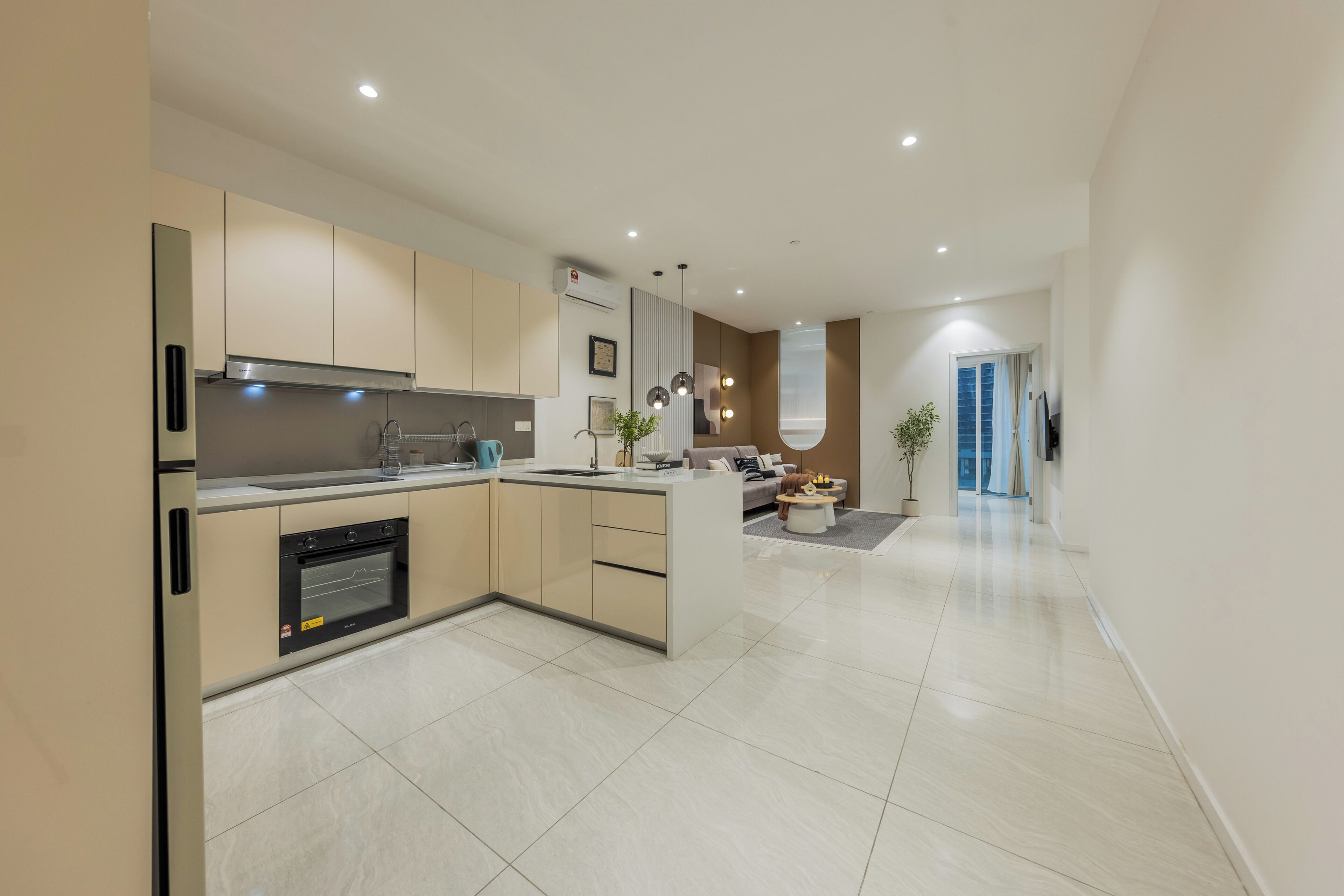 A modern kitchen with a built-in oven, a sink, and a dining area with a sofa and a coffee table.