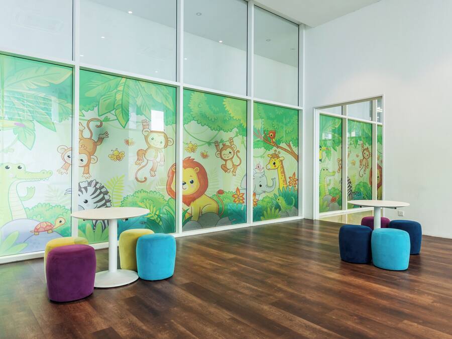 A children's play area with colorful furniture and jungle-themed wall decorations.