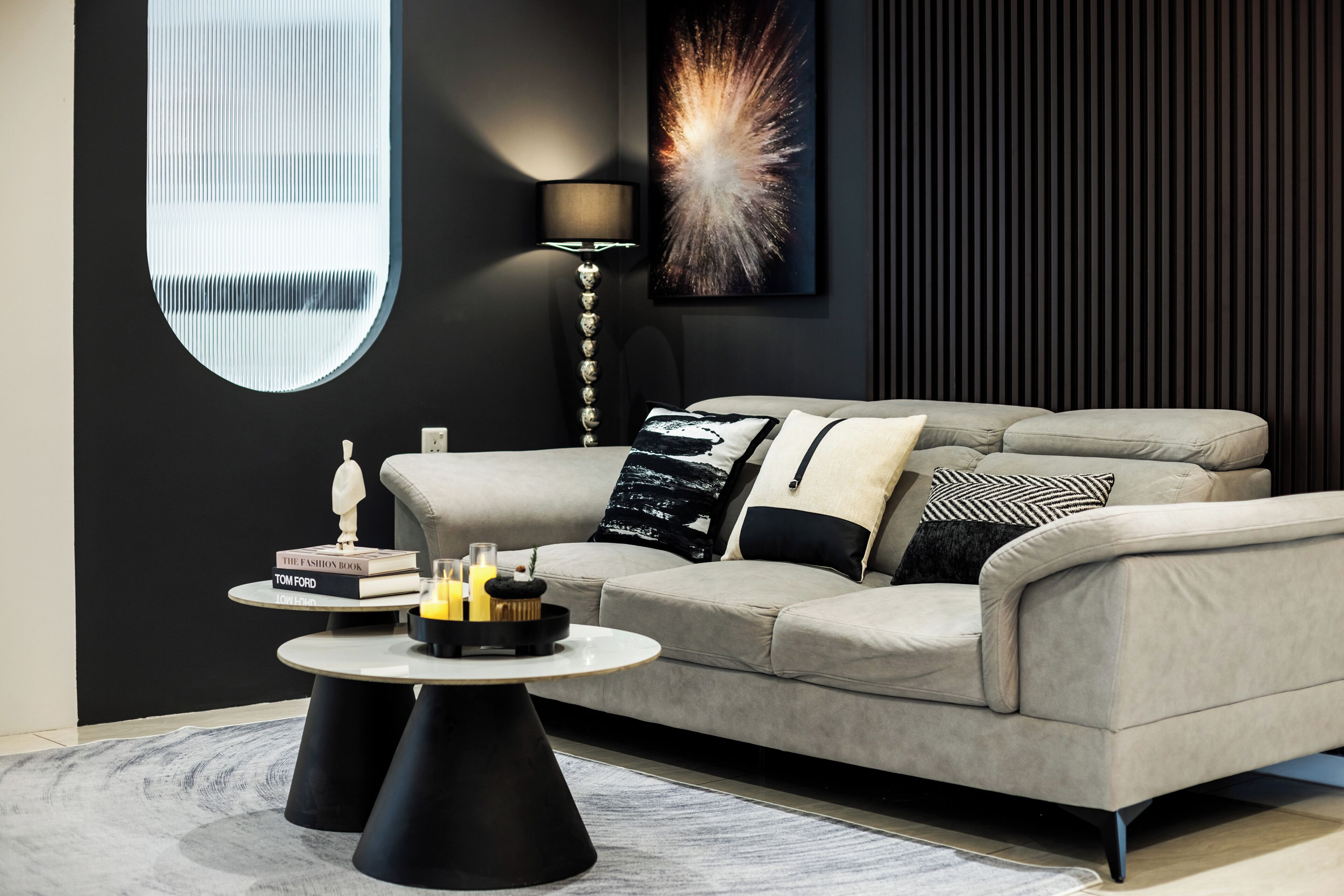 A modern living room with a sofa, a coffee table, and a lamp.