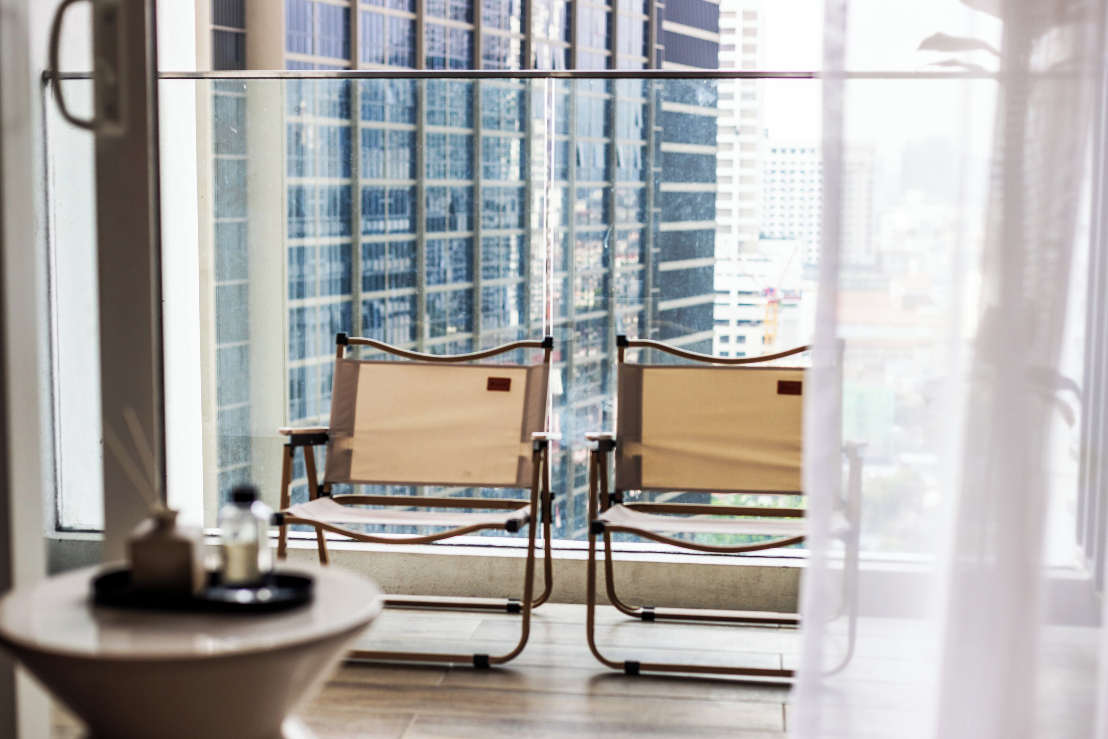 A room with two chairs facing a large window overlooking a cityscape.