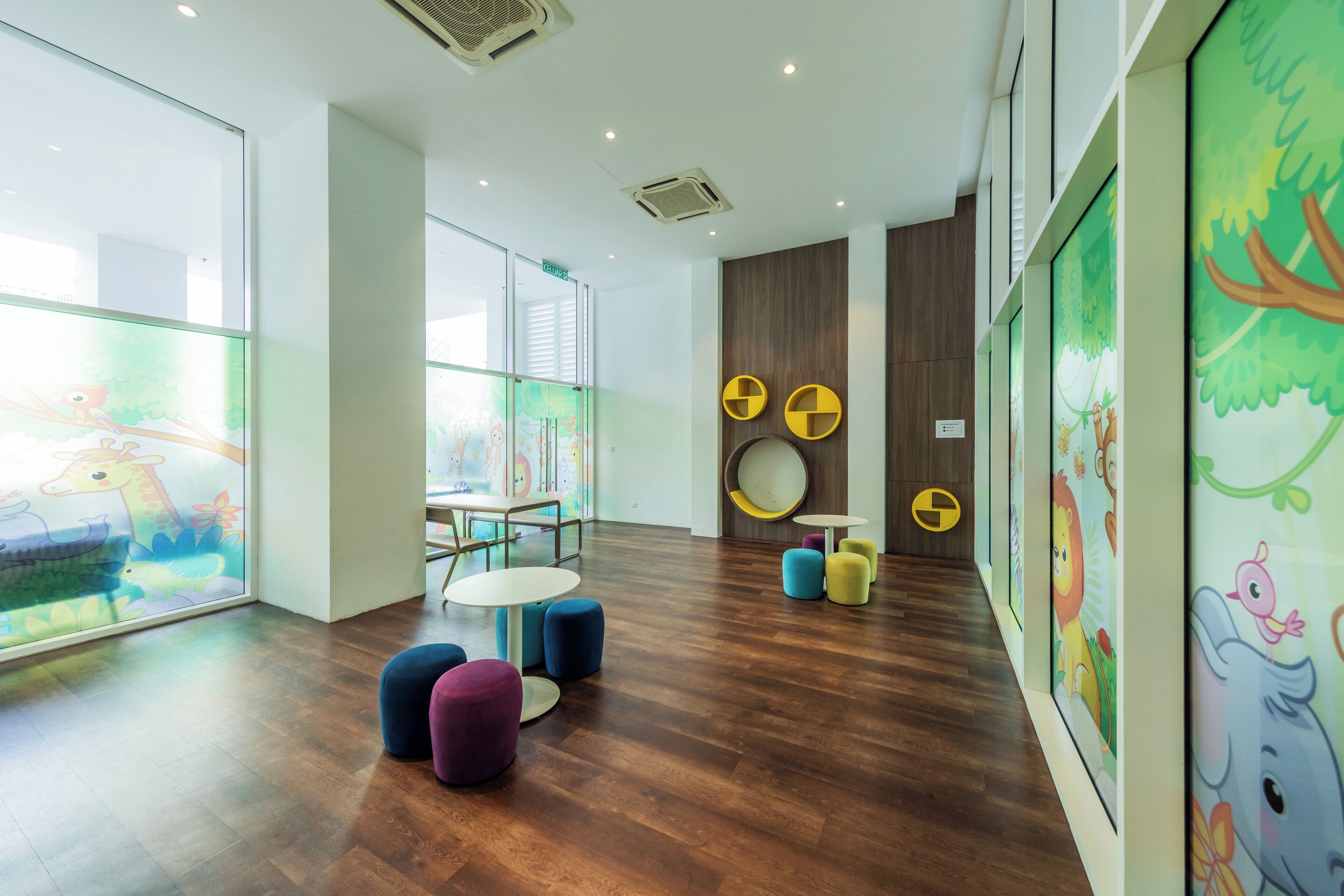 A modern children's play area with colorful furniture and artwork on the walls.