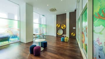 A modern children's play area with colorful furniture and artwork on the walls.
