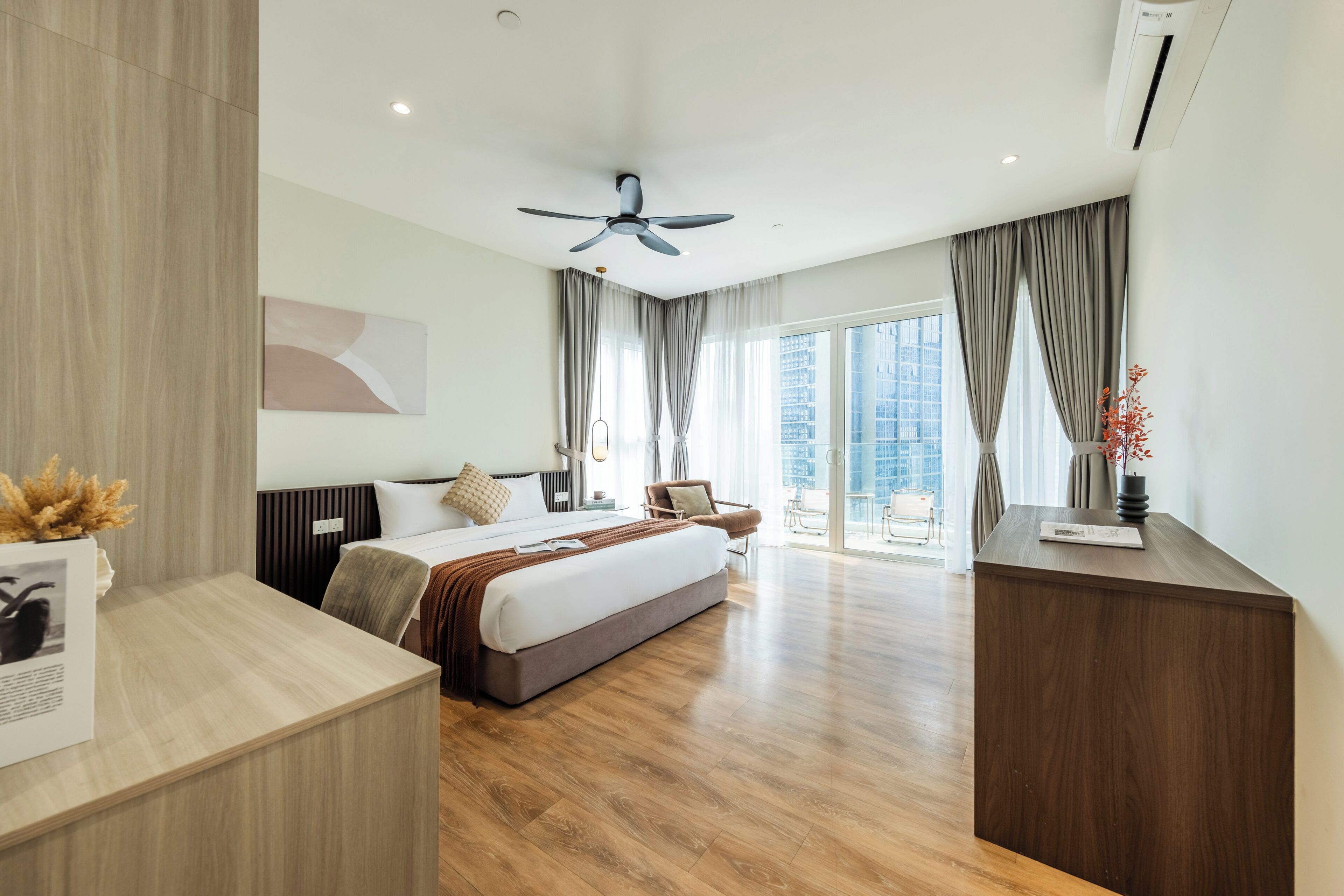 Ein modernes Hotelzimmer mit einem großen Bett, einem Schreibtisch und Blick auf die Stadt.