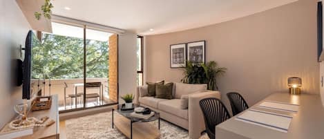 A modern living room with a sofa, coffee table, and dining area.
