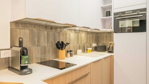 Eine moderne Küche mit integrierter Kaffeemaschine, Wasserkocher und Toaster auf der Arbeitsfläche.