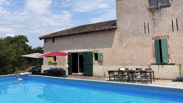 A building with a swimming pool, outdoor seating, and a clear sky. - Une Belle Histoire holiday home (Sainte-Livrade-sur-Lot)