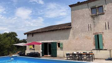 Un edificio con piscina, area relax all'aperto e cielo sereno.