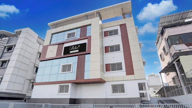 Um edifício de vários andares com design arquitetônico moderno, com uma placa de identificação em destaque e entrada com portão.