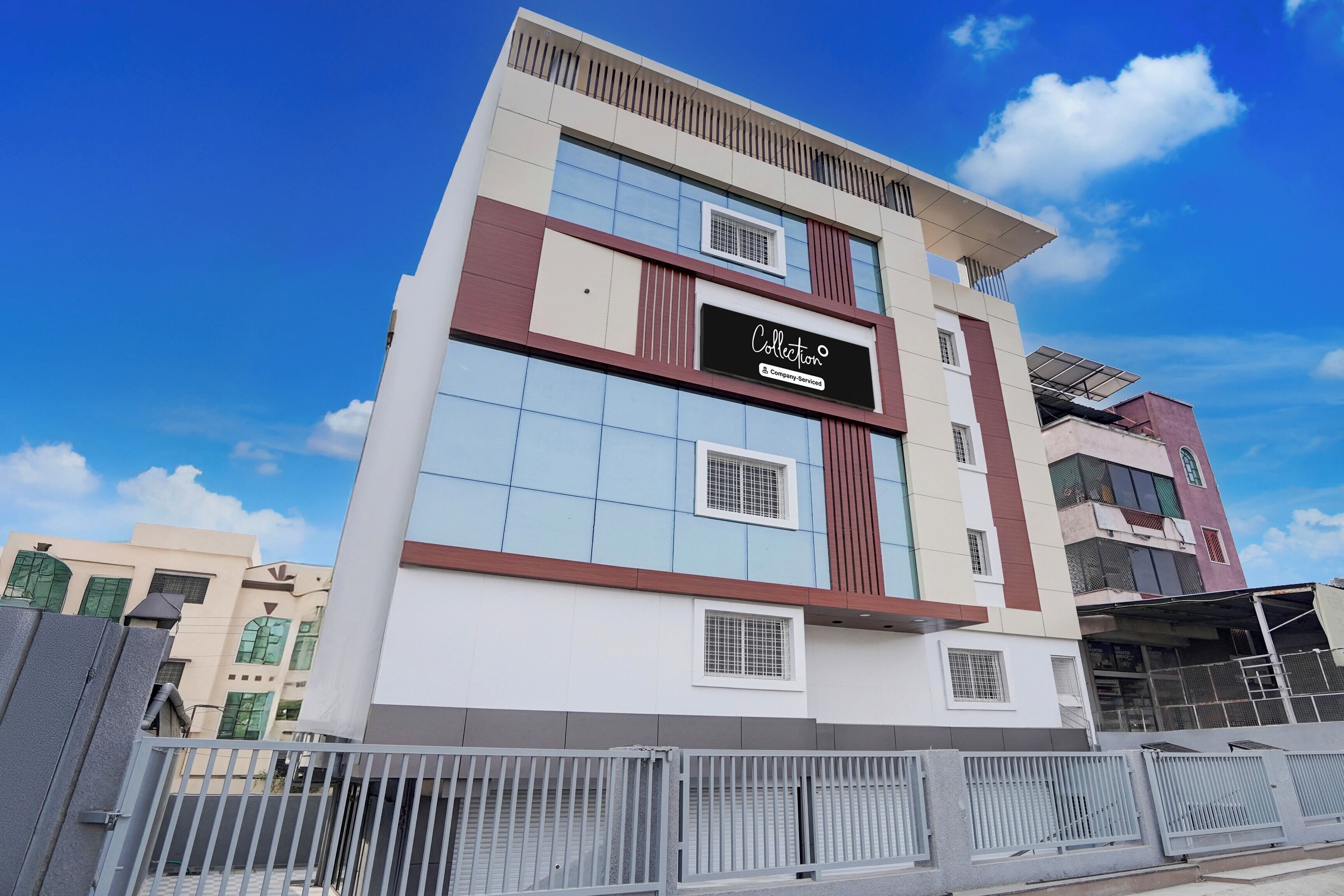 Un edificio de varios pisos con un letrero llamativo que dice 'Collection Company-Serviced'.