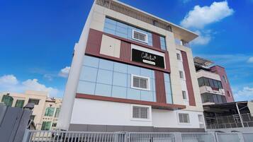 Un edificio de varios pisos con un letrero llamativo que dice 'Collection Company-Serviced'.