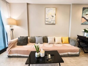 A modern living room with a sofa, a coffee table, and a lamp. - Sea View 2 Bed Room Best Location (Muang Pattaya)