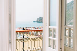 A view of a beach with tents and umbrellas, a rocky cliff, and the sea. - Alluz - Chalet by the sea (Nazaré)