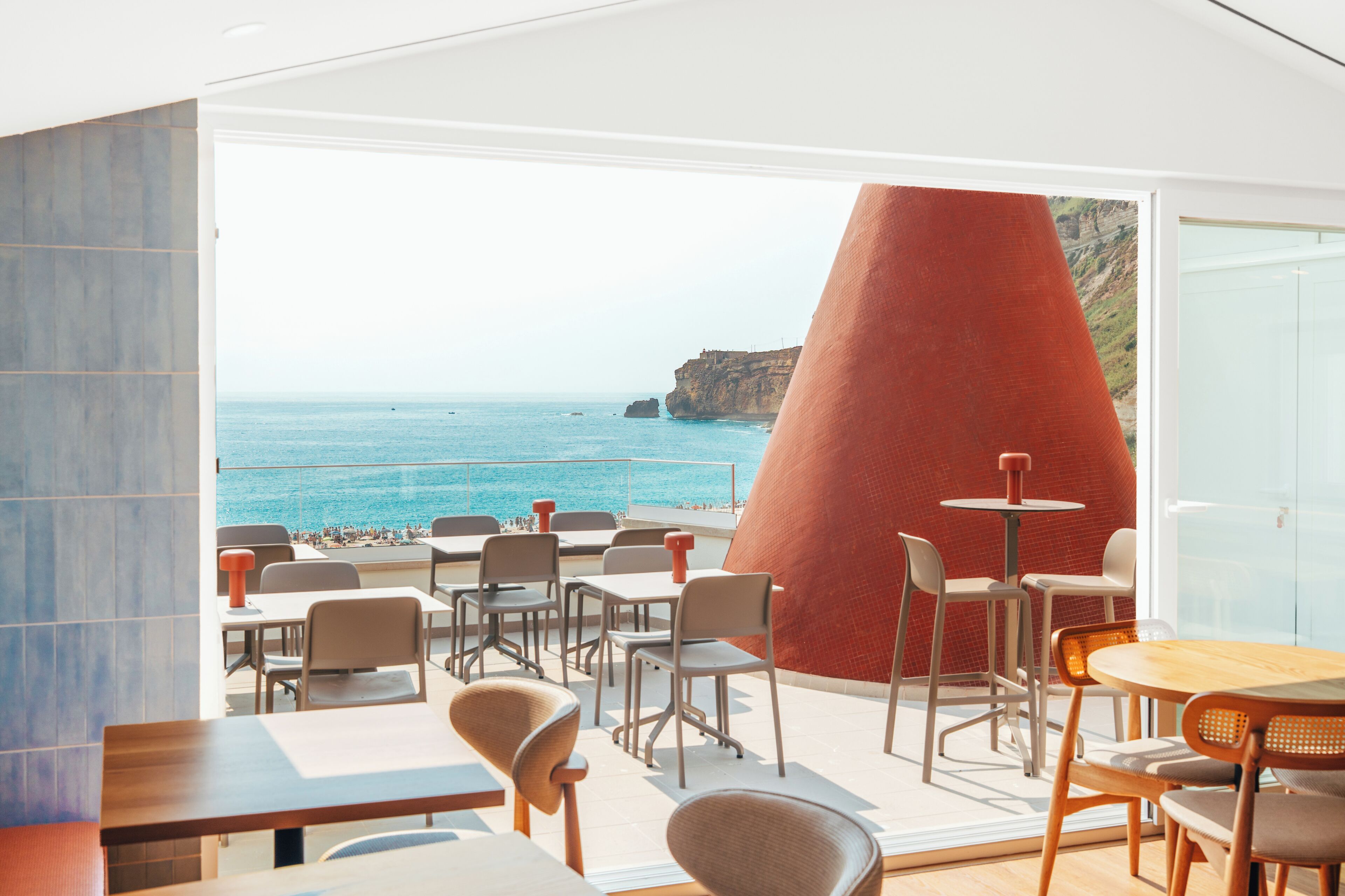 Un restaurant doté d’une terrasse offrant une vue sur la plage et la mer.
