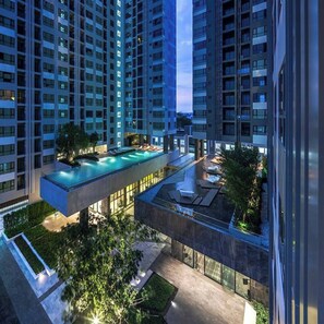 A high-rise building with multiple balconies and a rooftop swimming pool. - Pattaya Central I Near The Beach I Nice Pool (Muang Pattaya)