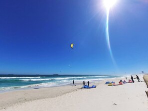 A beach with people, kites, and tents. - Amazing View For Less Bloubergstrand Beachfront (Cape Town)