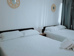 A hotel room with two beds, white linens, a bedside table with a lamp, and a wall decoration. - Spacious 1-Bedroom Apartment with Shared Pool in Punta Cana (Punta Cana)
