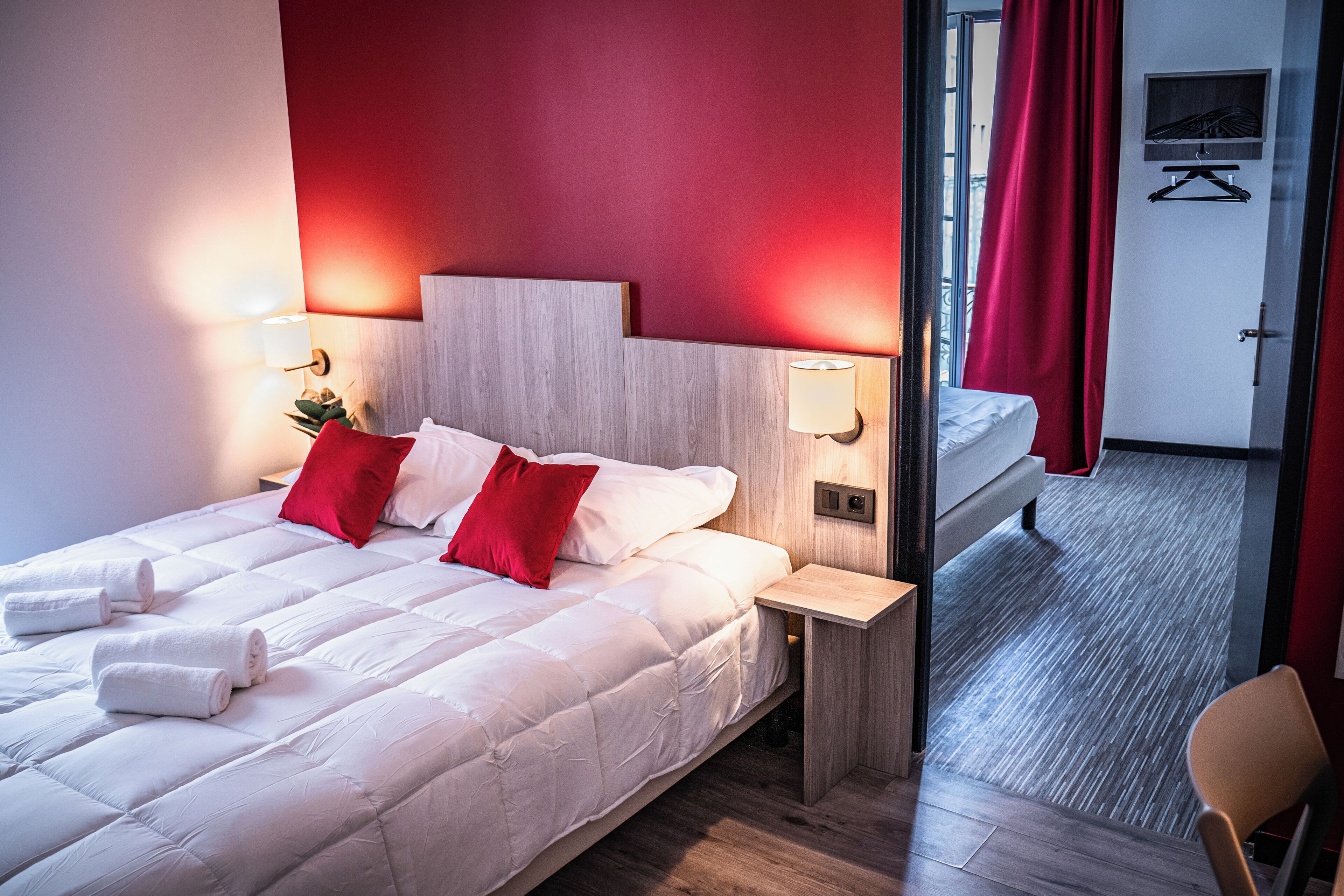 Une chambre d’hôtel avec un lit, une table de chevet, une chaise et une vue sur l’extérieur.