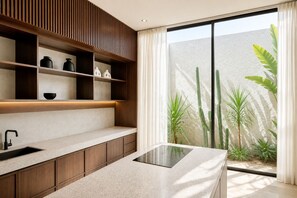 A modern kitchen with a built-in stove, wooden shelves, and a large window with plants. - Modern 2BR Private Pool Villa Near Pererenan Beach & Canggu (Badung)