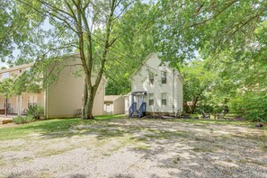 A two-story house with a front porch, a covered staircase, and a gravel driveway. - Walk to University of Akron! Game Day Getaway (Akron)