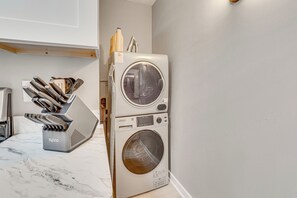 A compact, modern kitchen with a built-in washing machine and dryer, stainless steel appliances, and a marble countertop. - Walk to University of Akron! Game Day Getaway (Akron)