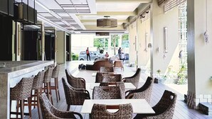 A spacious indoor dining area with high ceilings, a central bar, and a view of the outdoors. - Nordic Nest Makati (Makati City)