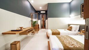Una camera d'albergo con un letto, una scrivania, una sedia e una pianta.