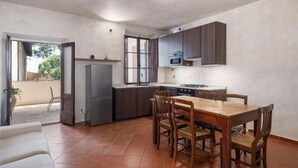 Uma cozinha compacta com área de refeições, geladeira, micro-ondas e fogão.
