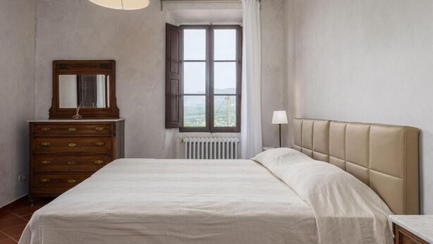Quarto com cama, penteadeira, janela e abajur.